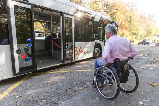 Rollstuhlfahrer steigt in einen Bus.