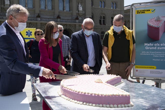 Patrick Mathys und Virginie Masserey vom BAG verteilen Kuchen an Geimpfte auf dem Bundesplatz.