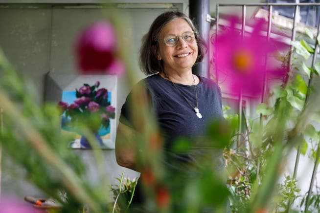Mara Meier arbeitet in der ZB und ist gleichzeitig Schriftstellerin. Foto beim Gartensitzplatz mit ihren Blumen und selbstgemaltem Gemälde im Hintergrund.
