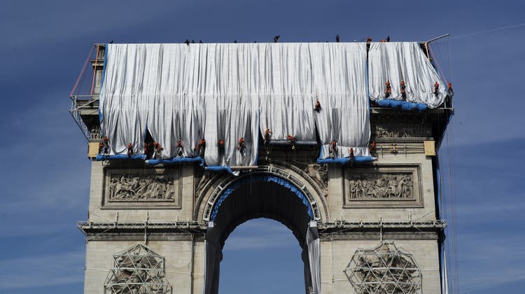 Industriekletterer umwickeln die Hülle des Arc de Triomphe mit roten Seilen. (Rafael Yaghobzadeh / AP)