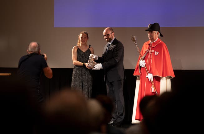 Der Gemeinderat Arno Grüter überreicht der Leichtathletin Lieke Wehrung den Preis.