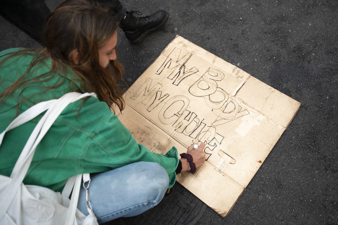 Eine Demonstrantin gestaltet ein Plakat.