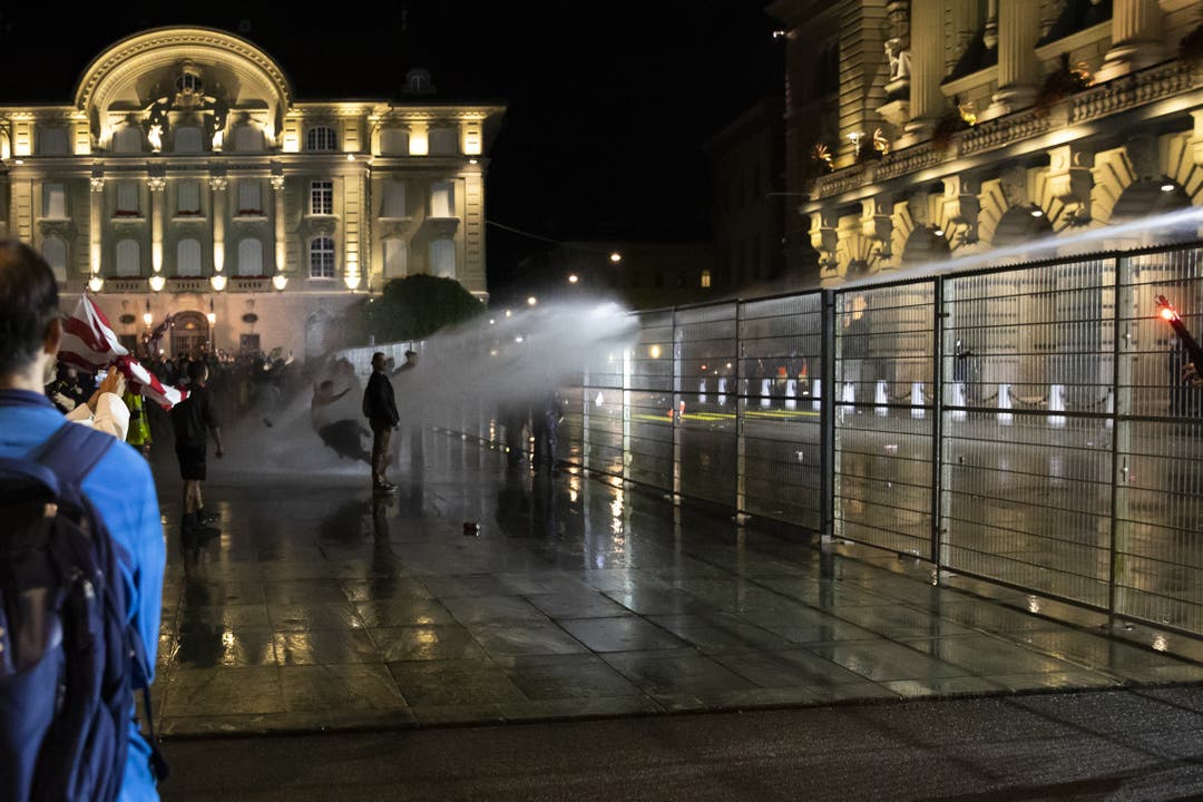 Die Polizei setzt den Wasserwerfer gegen die Demonstranten auf dem Bundesplatz ein. Diese zeigen sich unbedindruckt.