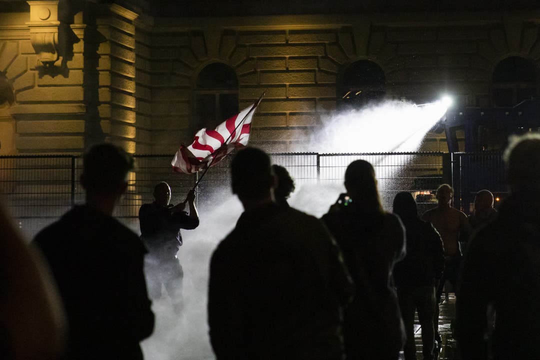 Die Polizei setzt den Wasserwerfer gegen die Demonstranten auf dem Bundesplatz ein.