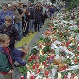 Trauernde Menschen vor dem Zuger Regierungsgebäude, in dem am 27. September 2001 bei einem Attentat 14 Menschen getötet und 18 weitere verletzt wurden. (Bild: Christof Borner- Keller (Zug, 29. September 2001))