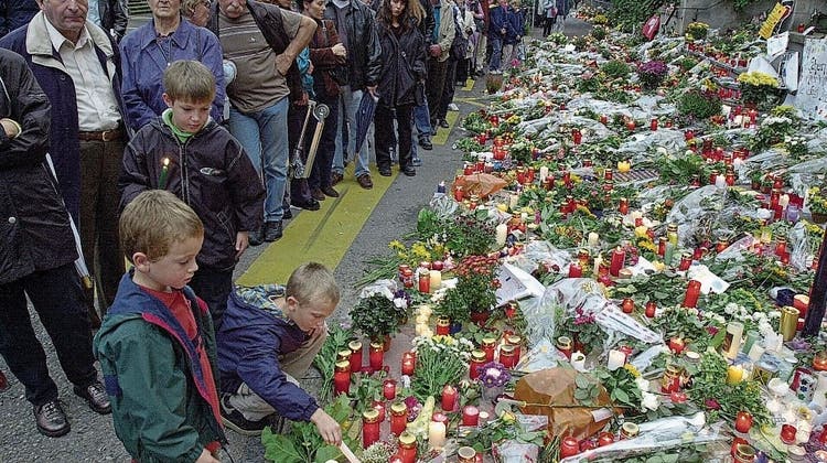 Trauernde Menschen vor dem Zuger Regierungsgebäude, in dem am 27. September 2001 bei einem Attentat 14 Menschen getötet und 18 weitere verletzt wurden. (Bild: Christof Borner- Keller (Zug, 29. September 2001))