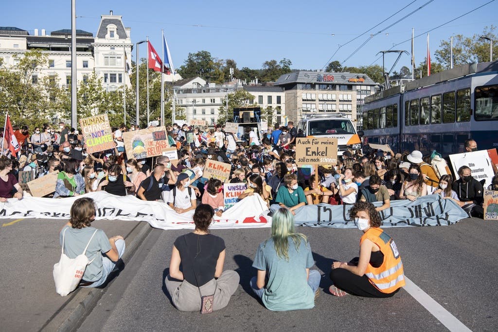 Die Demonstrierenden machen eine Sitzblockade auf der Strasse beim Bürkliplatz.
