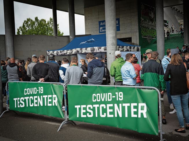 Menschen stehen Schlange vor einem Covid-Testcenter.