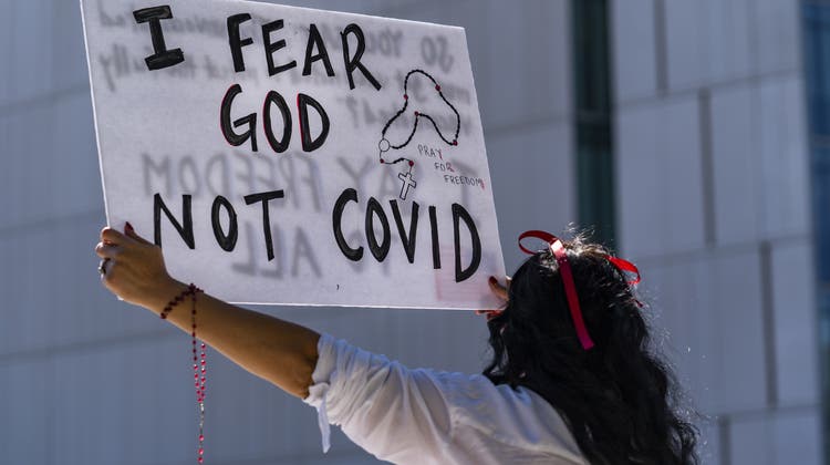 Religiöse Impfegegner in den USA (hier eine Demonstrantin in Los Angeles) nutzen eine Gesetzeslücke, um sich der mancherorts eingeführten Impfpflicht zu entziehen. (AP)