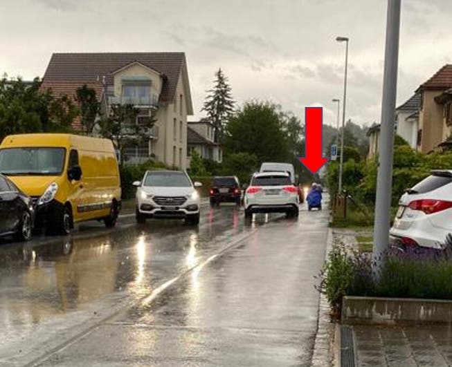 Autofahrer fahren in der Schlieremer Freiestrasse oft aufs Trottoir – sogar wenn ein Rollstuhlfahrer dieses benutzt (siehe roter Pfeil).