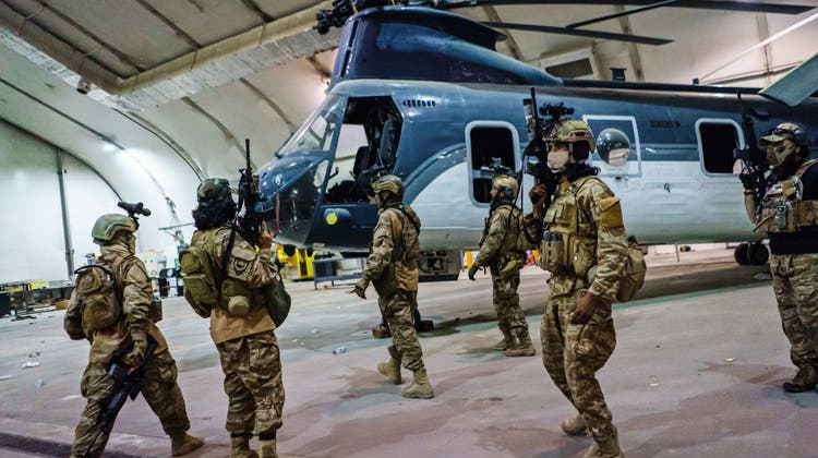 Taliban-Kämpfer am Flughafen von Kabul, vor einem flugunfähigen Helikopter. (Marcus Yam / Los Angeles Times)