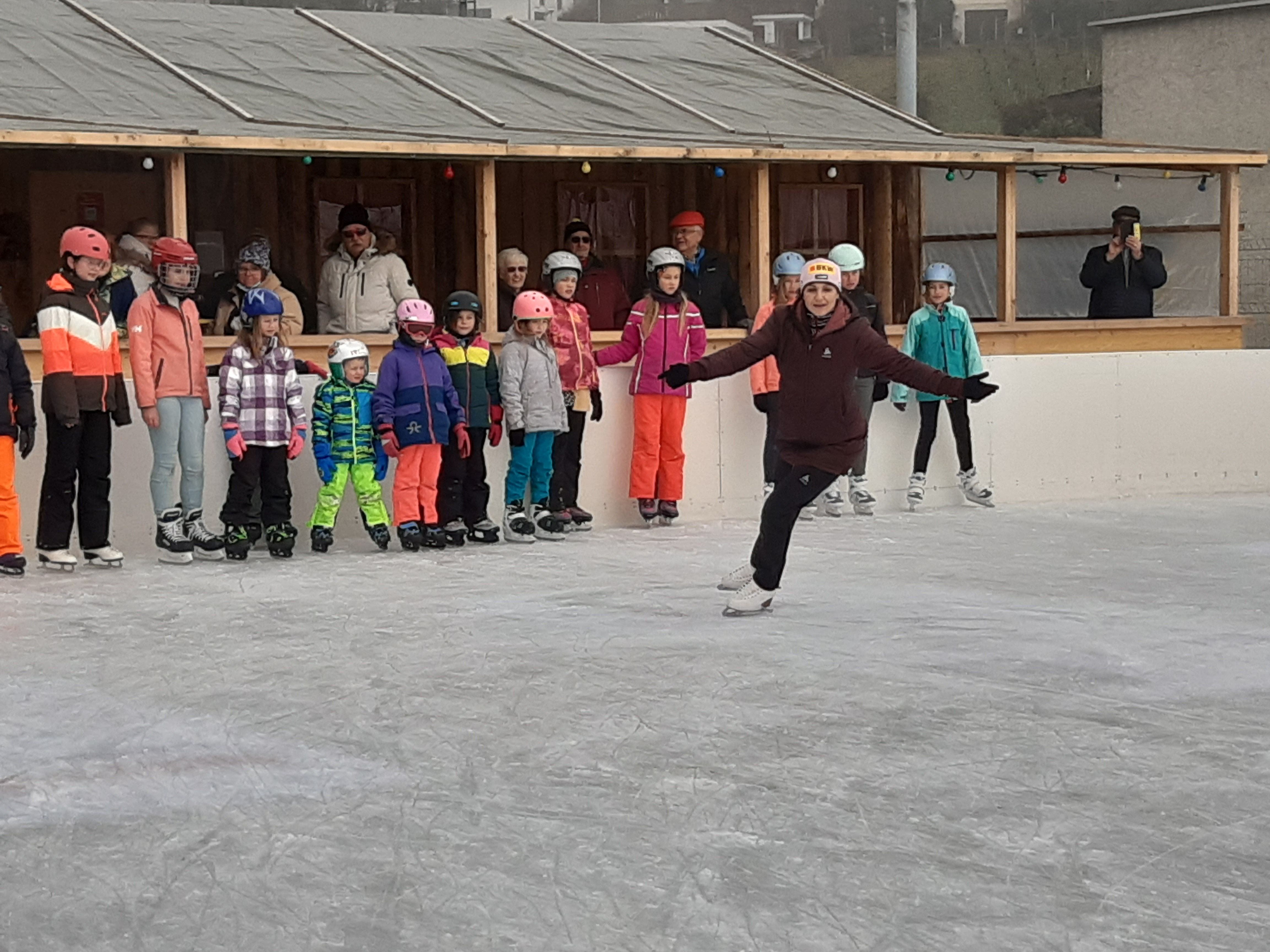 Die Kinder sehen aufmerksam zu, als Eiskunstläuferin Sarah van Berkel die nächste Übung erklärt.