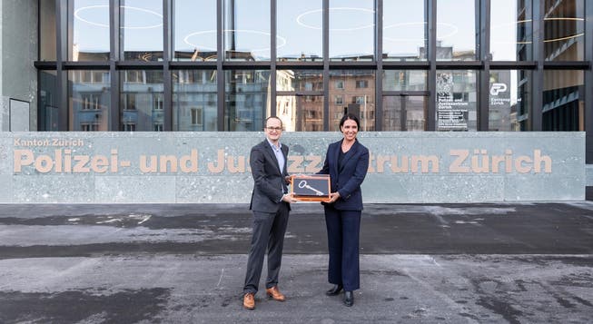 Rebecca Kull, Inhaberin HRS Real Estate AG, übergibt Regierungsrat Martin Neukom, Baudirektor, den Schlüssel für das Polizei- und Justizzentrum Zürich (PJZ).