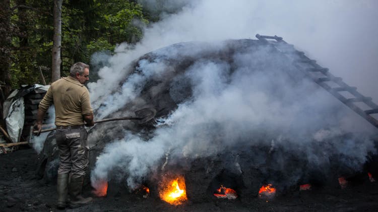 Ein Köhler aus dem Entlebuch brennt in der Nacht den Kohlemeiler aus. (Bild: Simon Meyer)
