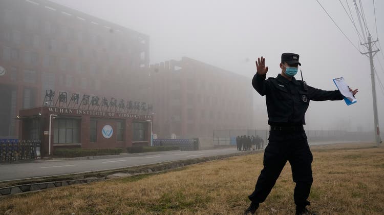 Ein Sicherheitsmann schickt Schaulustige vor dem Virologie-Institut in Wuhan weg. (Bild: Keystone)