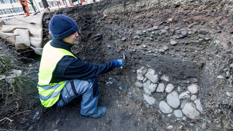 Grabungsleiter Johannes Wimmer bei der Arbeit auf dem kleinen Münsterplatz. Die unterste Steinmauer könnte römischen Ursprungs sein. (Kenneth Nars)