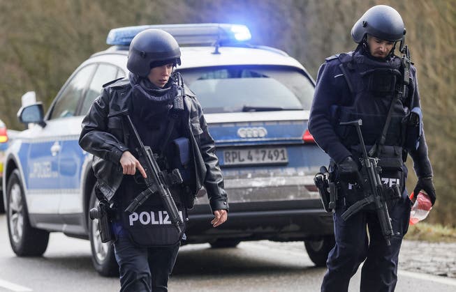 Schwerbewaffnete Polizisten in der Nähe des Tatorts