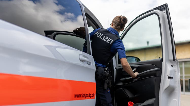 Symbolbild einer Thurgauer Kantonspolizistin mit einem Patrouillenfahrzeug. (Bild: Christian Merz/Keystone)
