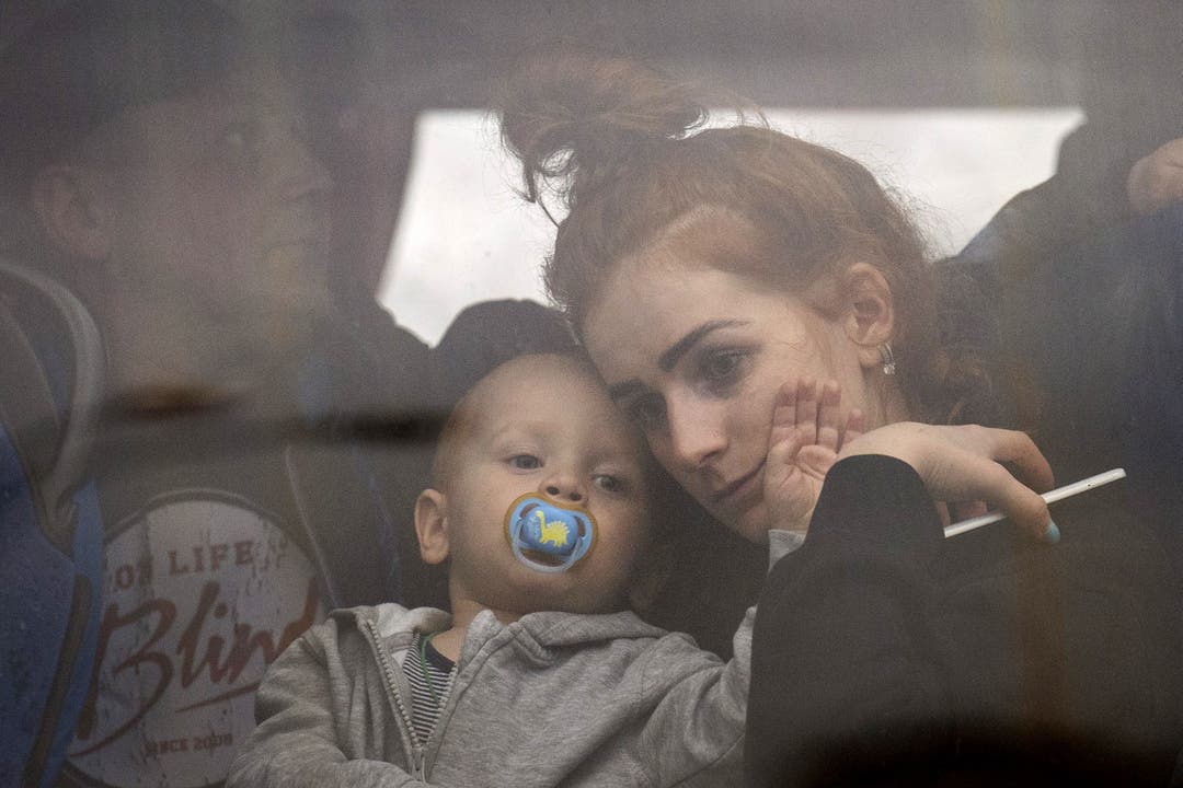 Eine Frau und ihr Baby verlassen Kiew in einem Bus. Tausende Menschen sind am Donnerstag geflüchtet.