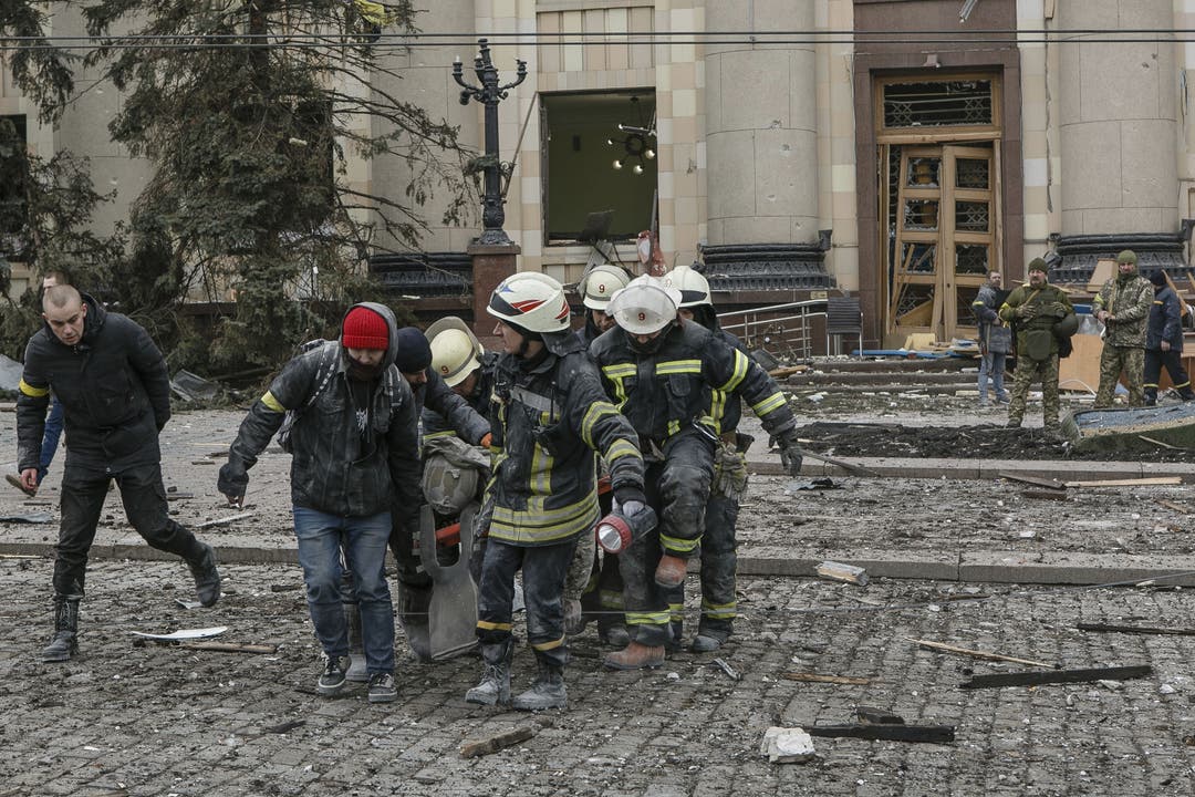 Rettungskräfte tragen ein Opfer aus dem zerstörten Regierungsgebäude in Charkiw. 