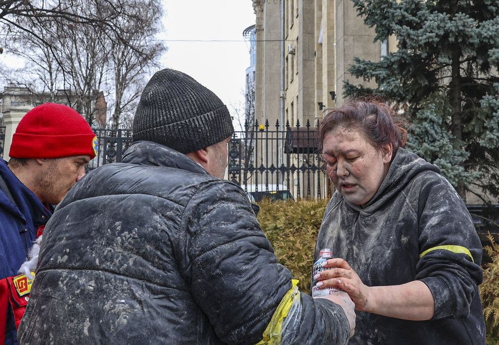 Menschen helfen einer verwundeten Frau nach dem Beschuss der russischen Armee in Kharkiv.