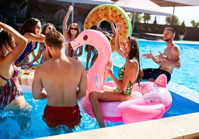 Eine Pool-Party mit aufblasbarem Flamingo und Donut.