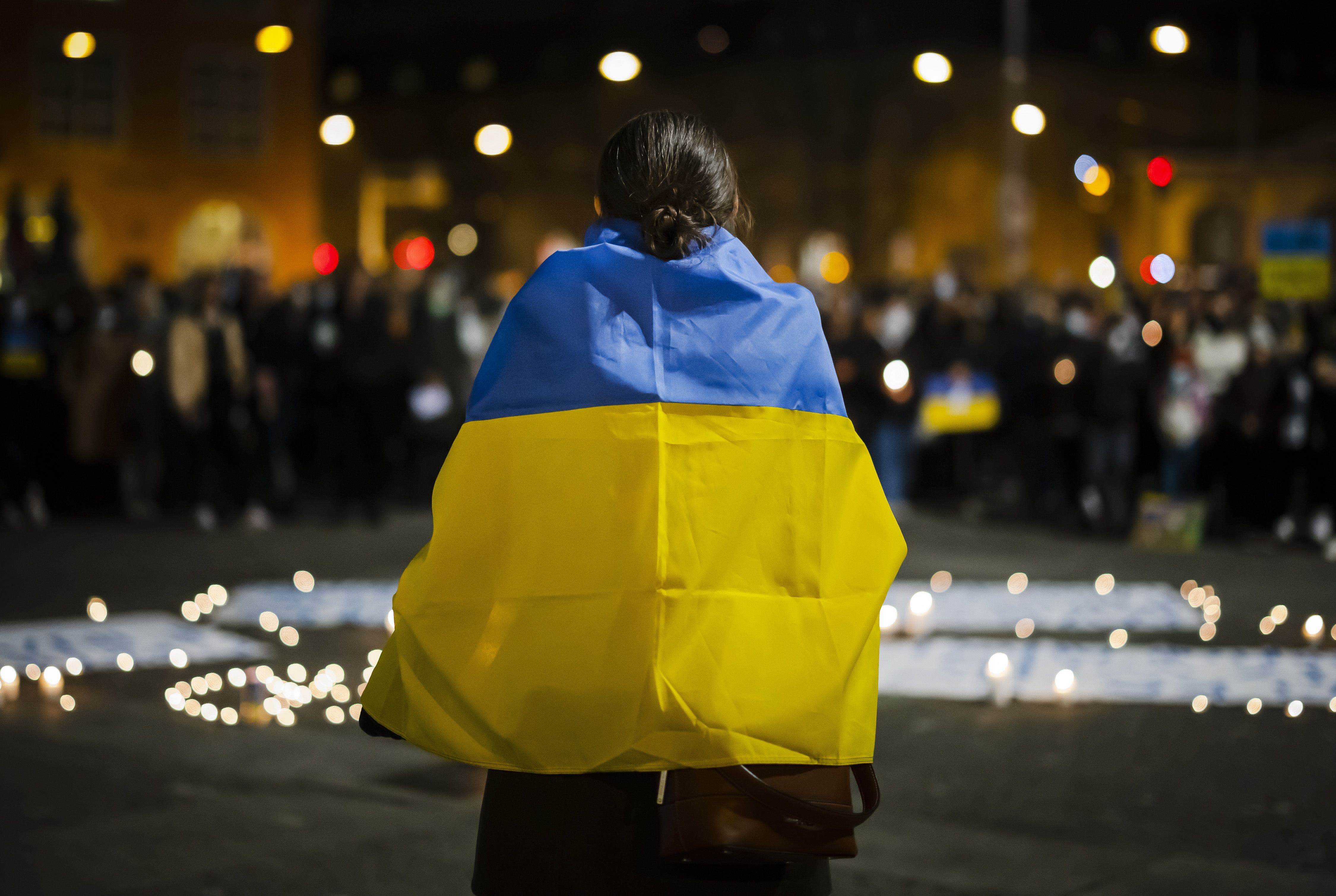 Eine Frau ist in eine ukrainischen Flagge gehüllt.