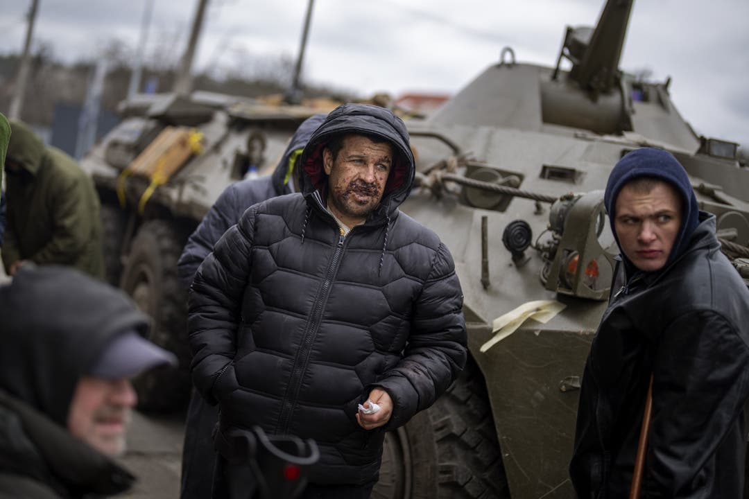 Ukrainische Männer nachdem sie auf der Flucht den Fluss Irpin in der Nähr von Kiew überquert haben.
