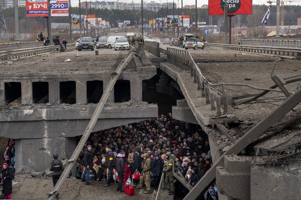 Ukrainer drängen sich unter einer zerstörten Brücke, als sie versuchen, über den Fluss Irpin aus Kiew zu fliehen.