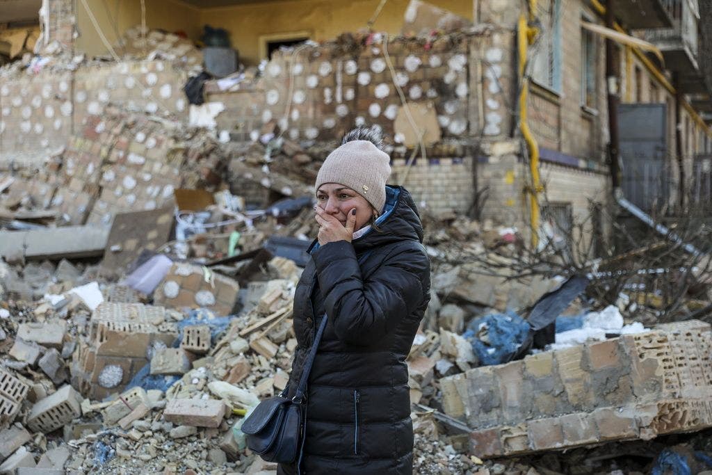 Eine Frau weint vor einem zerstörten Wohnhaus in Kiew.