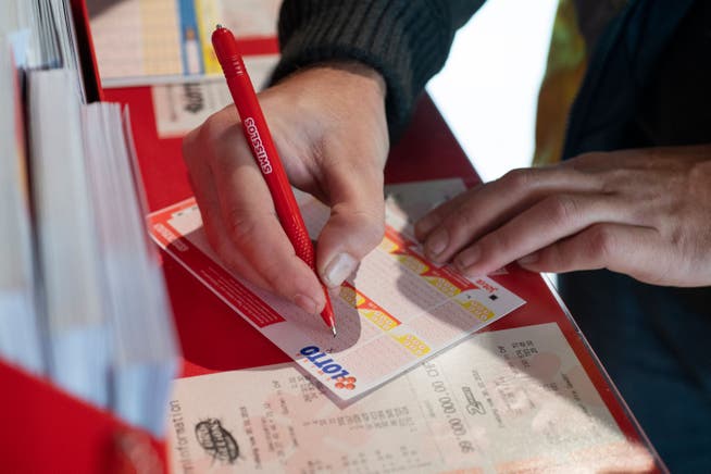 EIn Mann füllt einen Lottoschein aus. Tankstellenshop avec, Tankstelle Tamoil, Wettingen, 31. Oktober 2018. 