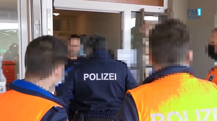 Polizisten der Kantonspolizei St.Gallen versuchen die Versammlung der Coronaskeptiker aufzulösen. (Screenshot: FM1 Today)
