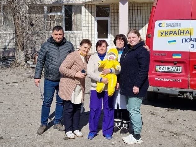 Eva's Helfer konnten den kleinen Mikhail (im gelben Baby-Dress) aus einem zerbombten Haus retten.
