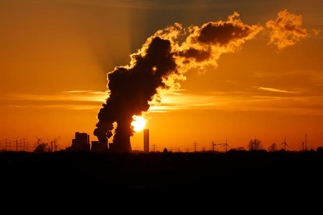 Damit muss Schluss sein, soll die Erderwärmung gestoppt werden. Das Kohlekraftwerk Niederaussem in Nordrhein-Westfalen vor glühendem Himmel.