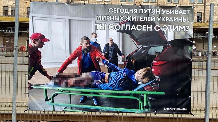 Plakataktion mit schwer erträglichen Bildern. Auf kyrillisch steht die Botschaft: «Gerade jetzt tötet Putin friedliche Zivilisten. Bist du damit einverstanden?» (Christoph Reichmuth/04.04.2022)