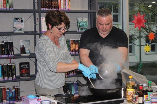 Autor Peter Denlo mit Veranstaltungsbesucherin Elsbeth Phillot beim Kochen in der Lengnauer Mediothek