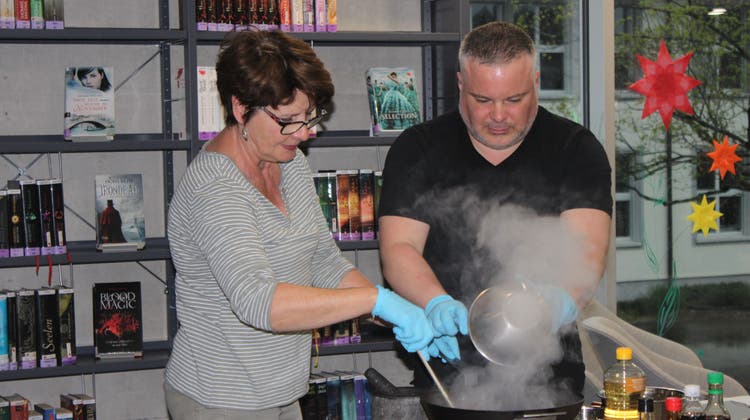 Autor Peter Denlo mit Veranstaltungsbesucherin Elsbeth Phillot beim Kochen in der Lengnauer  Mediothek (Margrit Renfer)