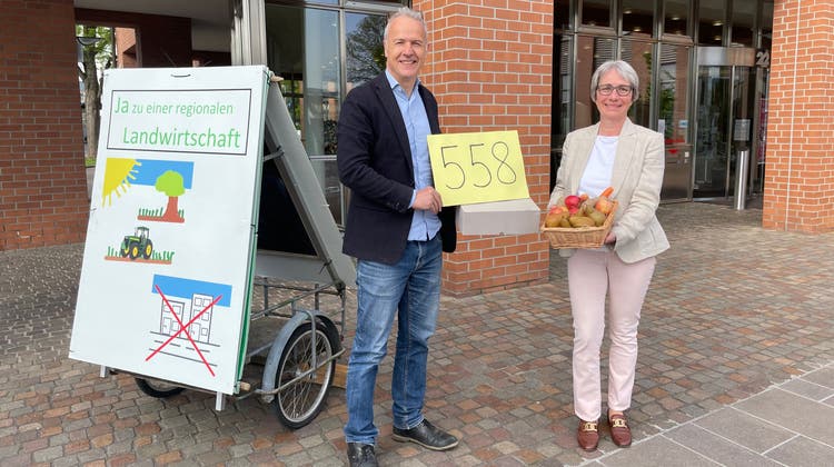 Bernhard Schmidt überreichte Stadtschreiberin Claudia Winkler vor dem Stadthaus 558 Unterschriften und einen Korb mit Früchten und Gemüse von Dietiker Bauern. (Florian Schmitz)
