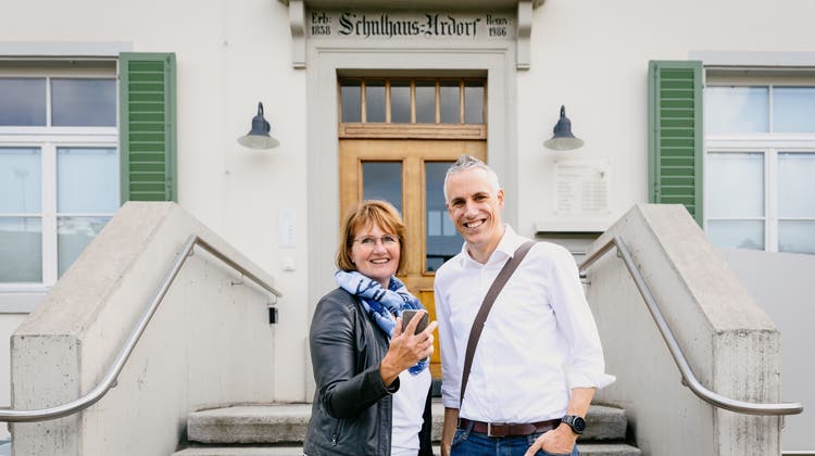 Gemeindepräsidentin Sandra Rottensteiner (EVP) und Leiter Stab Patrick Müller stehen vor dem Startpunkt des digitalen Dorfrundgangs, dem Bachschulhaus in Urdorf. (Valentin Hehli)