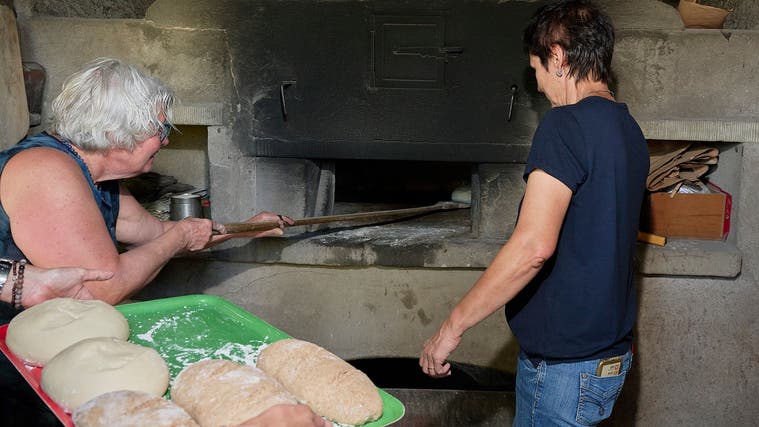 Priska Steiner und Irene Lehmann schieben die Brote in den Backofen. (José R. Martinez)