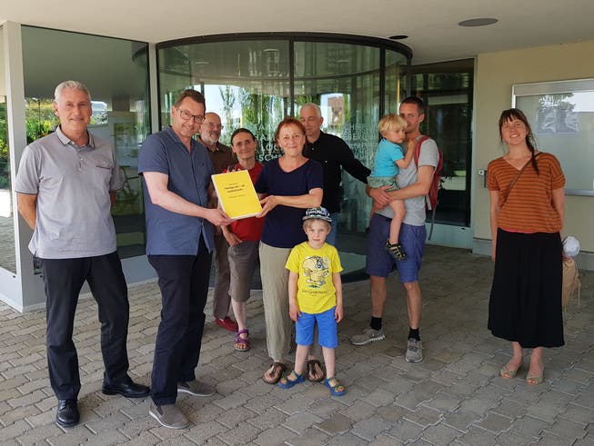 Barbara Ryser übergibt die Petition an den Küttiger Gemeindeammann Tobias Leuthard und Schreiber Robert Rütimann (l.)