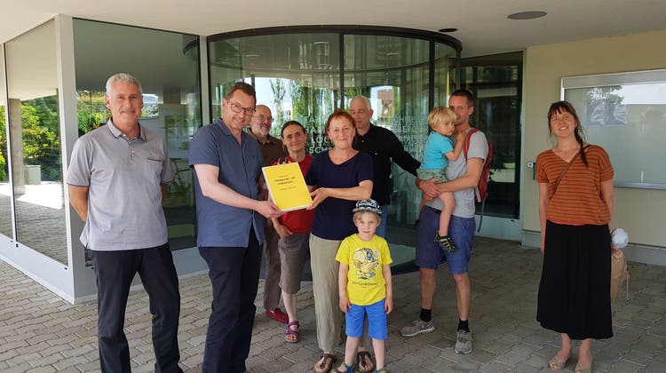 Barbara Ryser übergibt die Petition an den Küttiger Gemeindeammann Tobias Leuthard und Schreiber Robert Rütimann (l.) (Nadja Rohner / Aargauer Zeitung)
