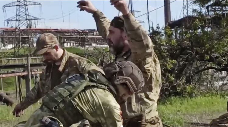 Russische Soldaten durchsuchen ukrainische Kämpfer beim Stahlwerk Asowstal in Mariupol. (Keystone)