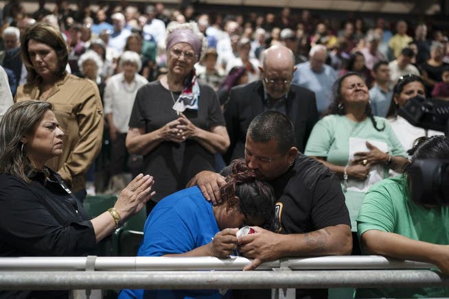 Anghörige trauern bei einem gemeinsamen Gebet . 
