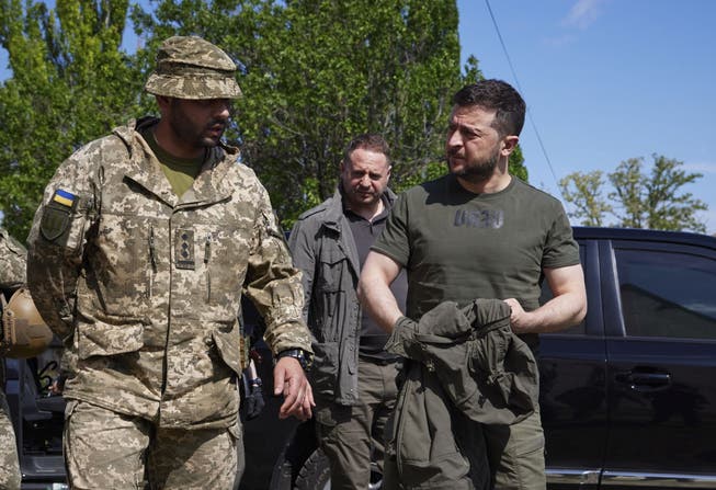Der ukrainische Präsident Wolodimir Selenski (r) trifft bei seinem Frontbesuch auf Soldaten seiner Armee.