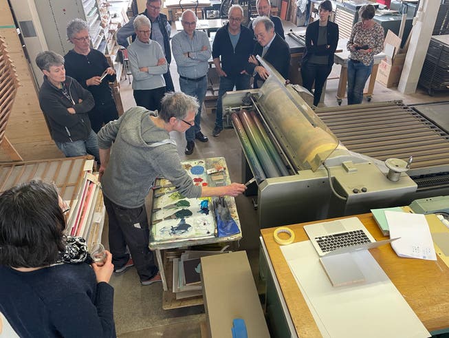 Urs Jost, Leiter der Druckwerkstatt, erklärt Mitgliedern des Rotary Clubs Lenzburg-Seetal die verschiedenen Arbeitsschritte an der Druckerpresse.