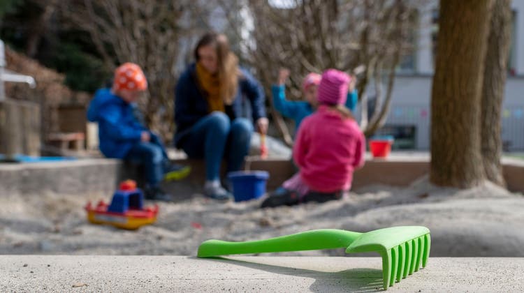 Kinder spielen unter Aufsicht einer Kindererzieherin im Sandkasten. Damit werden berufstätige Eltern entlastet. (Christian Beutler / Symbolbild)