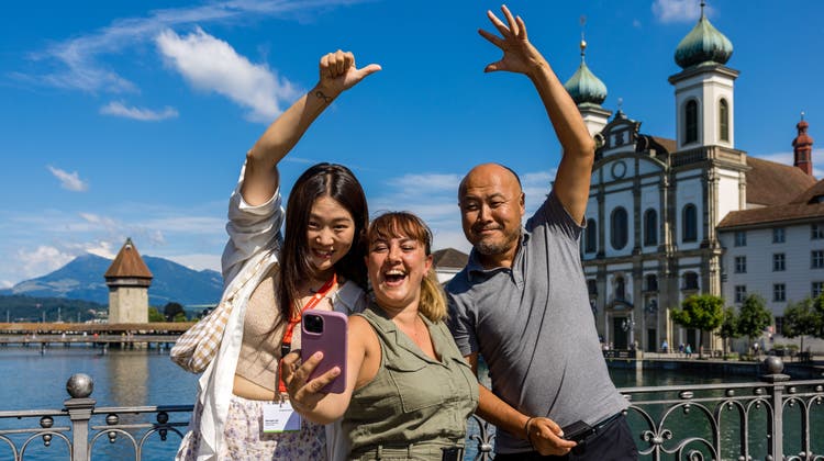 Die Influencer Seung Lee (Südkorea), Teresa Gomez (Grossbritannien) und Xiangming Cui (China), von links nach rechts, posieren vor den Wahrzeichen der Stadt Luzern. (Bild: Philipp Schmidli (26. Juli 2022, Luzern))