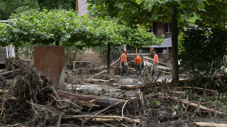 Einsatzkräfte des Zivilschutzes räumen nach der Überschwemmung des Flusses Emme beim Hotel Landgasthof Kemmeriboden-Bad auf. Heftige Niederschläge haben am Montag in der Gemeinde Schangnau zu Überschwemmungen geführt. (Keystone)