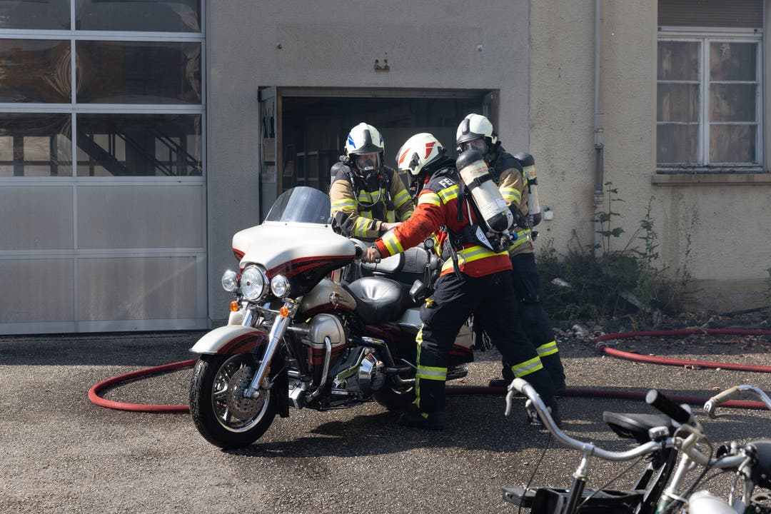 Die Feuerwehr bringt ein Motorrad in Sicherheit.